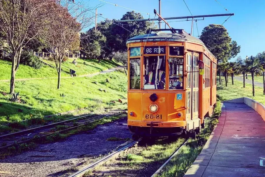 Le tramway historique orange F Line roule sur une voie dans le quartier 卡斯特罗 de San Francisco.