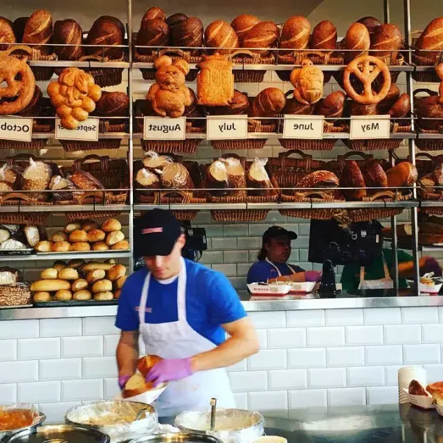 Los panaderos delian pan de masa madre在贝博体彩app的Boudin面包店.